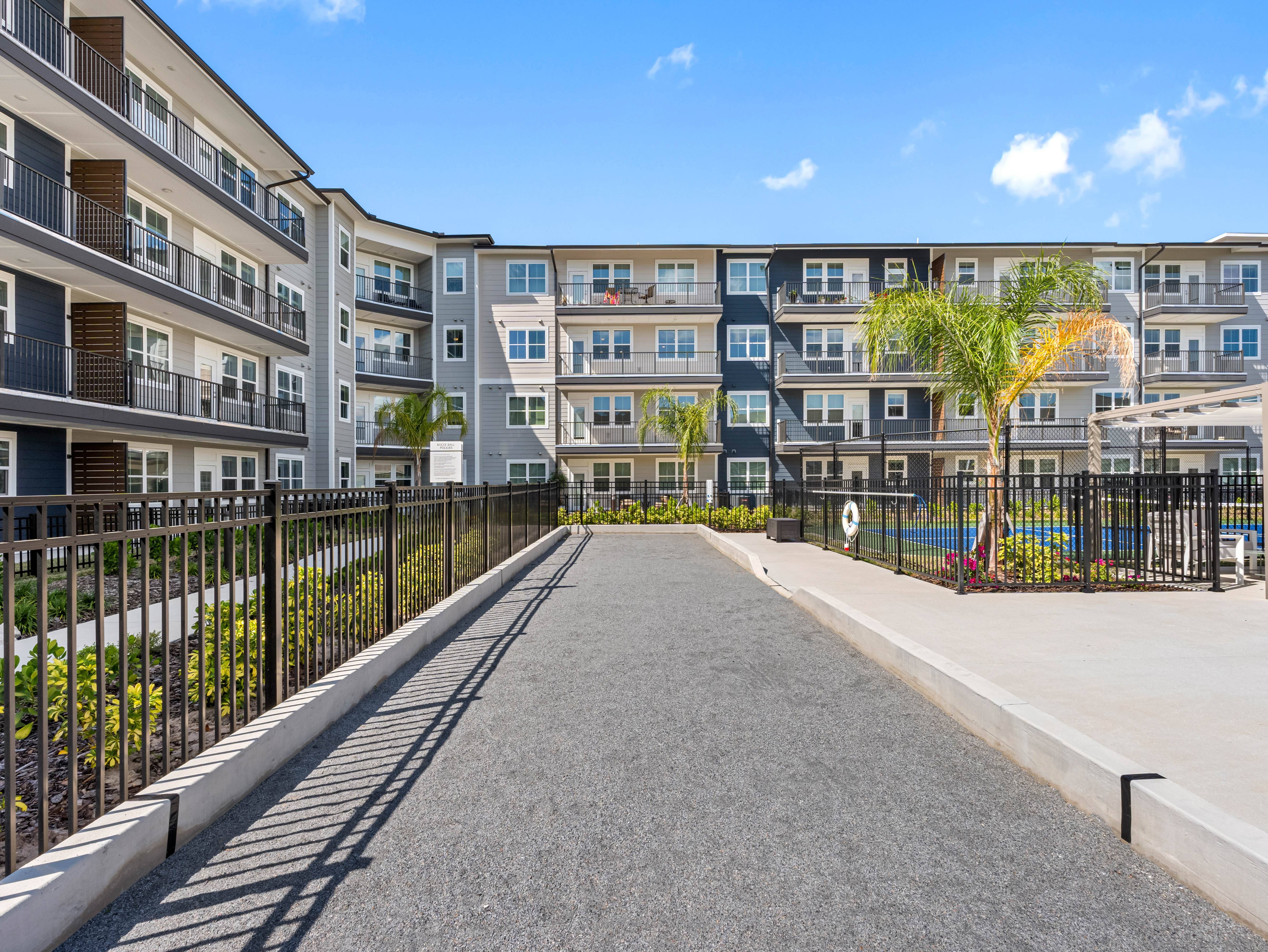 A long, narrow walkway separates two rows of apartment buildings.
